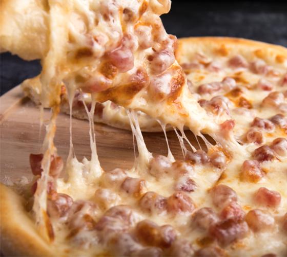pizza shown with a slice being lifted with cheese pulls