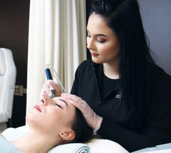 Esthetician student providing facial service on client in the spa