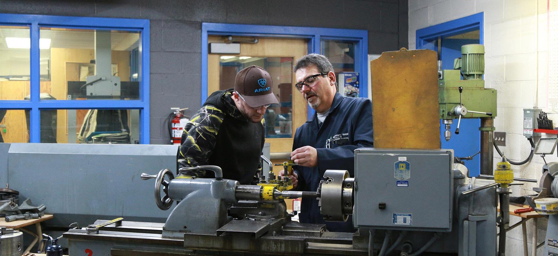 One male Mechanical Techniques - Machine Shop student listens closely to his instructor. 