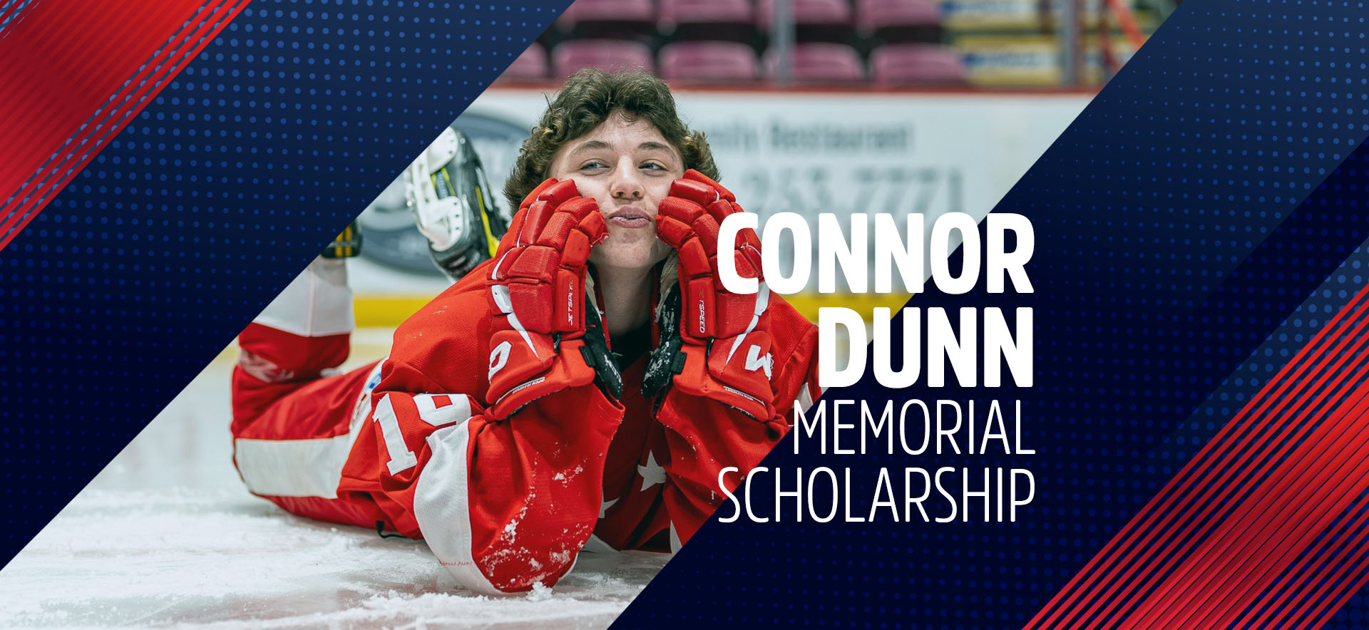 Connor Dunn laying on the ice with Soo Jr. Greyhounds uniform