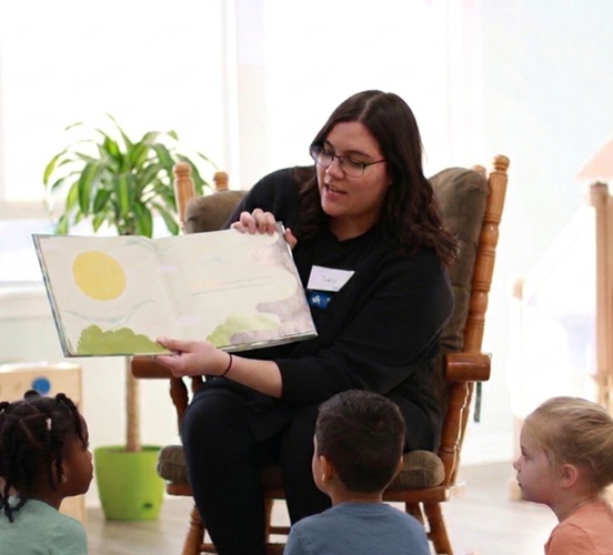 ECE student reading a book to young children