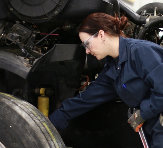 Women in trades student working in heavy equipment lab on transport