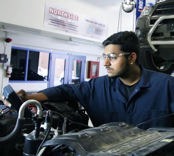 One male Automotive Service Technician student executes some diagnostic tests on an engine.                                                              