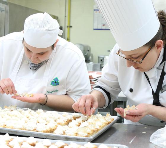Two female Sault College Culinary students prepare pastries in one of the culinary kitchens.