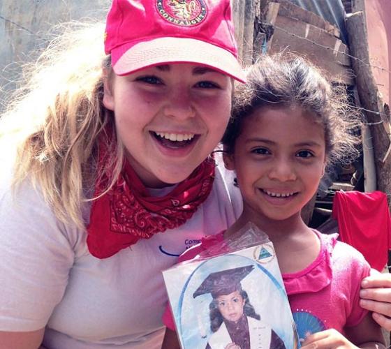 Nursing student smiling with little girl in Nicaragua.