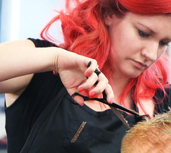 Female hairstylist student practices on a mannequin.