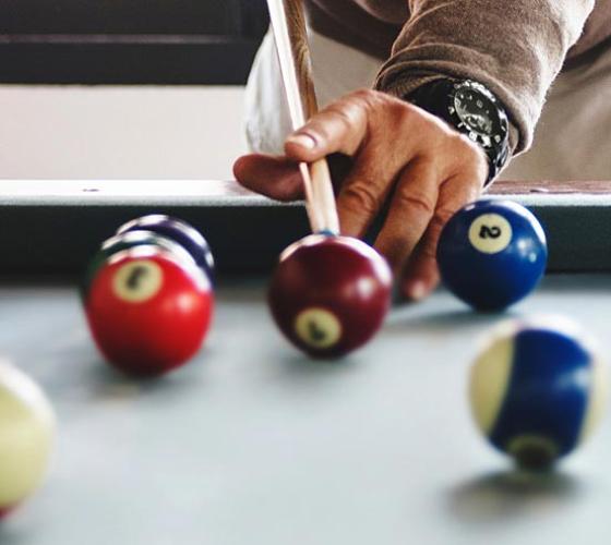 Male hands taking a billiard shot.