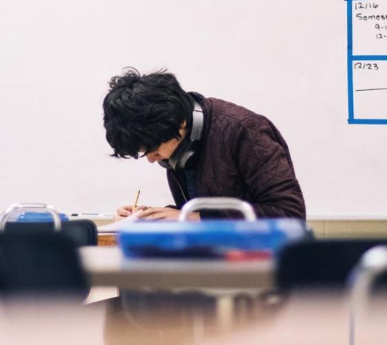 Young male student working on a paper.