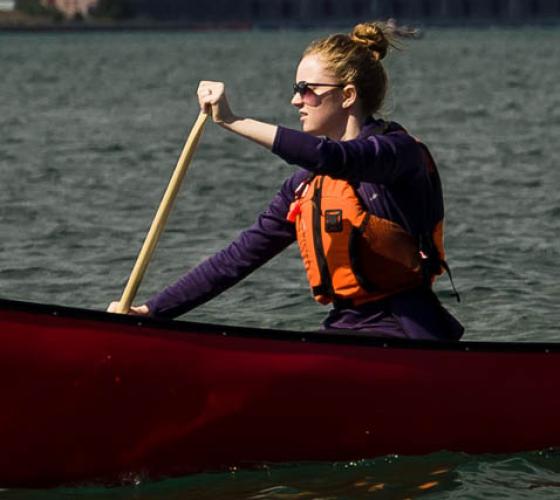 student paddling in canoe on river