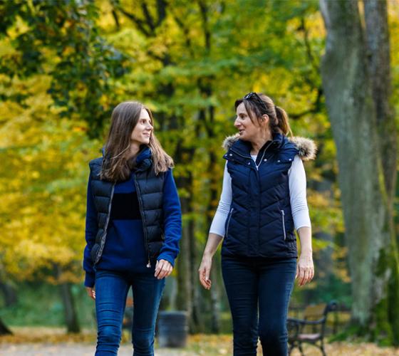 Two young women walking in park.