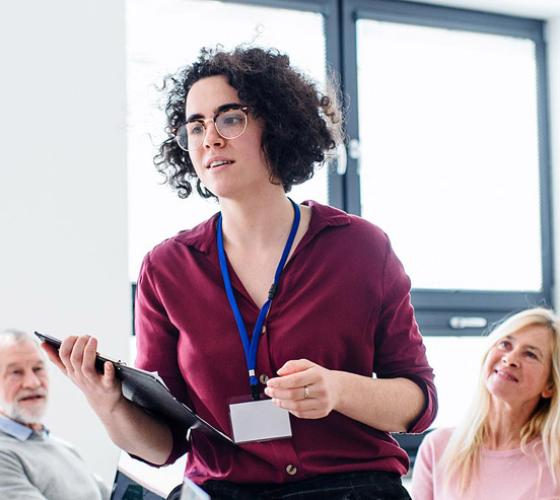 Female instructor teaching a class of adults.