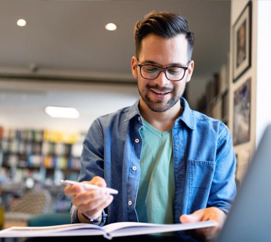 Male student marking up book report.