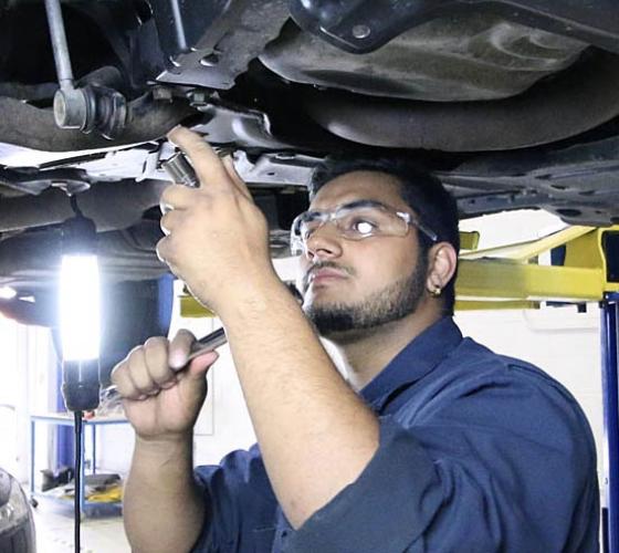 male looking up at engine under car