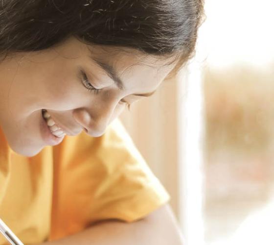 Girl looking down and writing