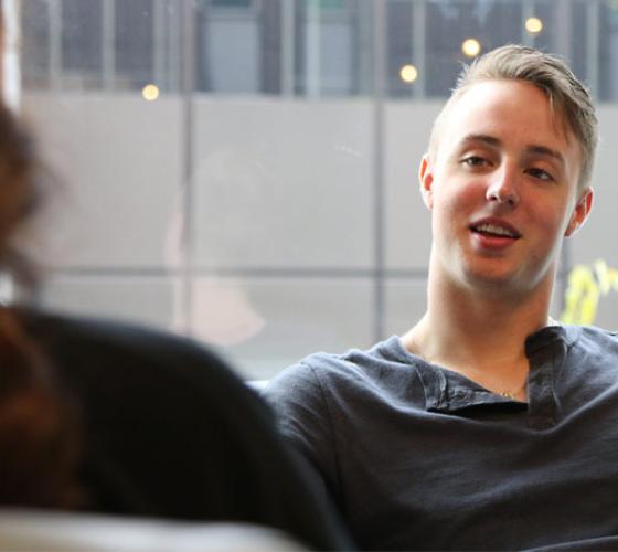 student sitting in conversation with another person