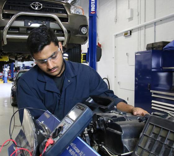 Male student working on automotive parts