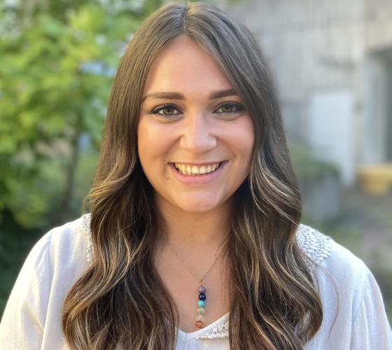 Recruiter Carly smiling looking at the camera standing outside on campus
