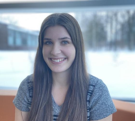 Seanna student ambassador for School of Natural Environment smiling for camera sitting in front of window