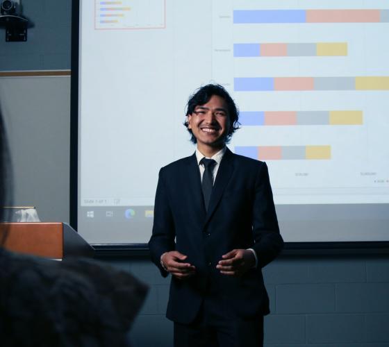 Business student at front of class doing a presentation