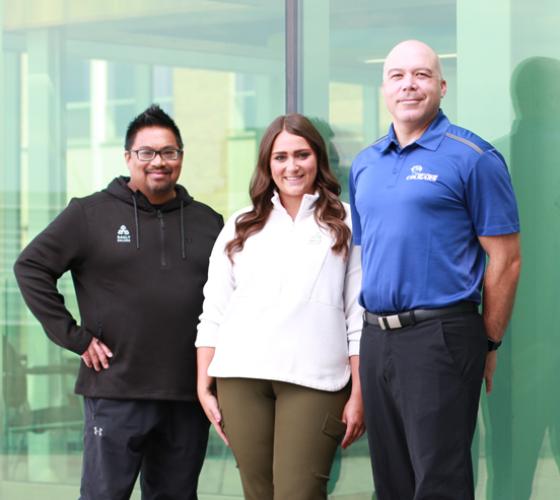 Three of our recruiters posed in front of wall of windows