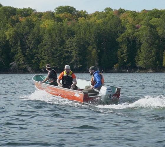 School of Natural Environment students in a boat on the lake learning safe motor operation