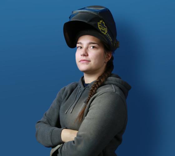 Skilled Trades student wearing a welding mask lifted up off her face
