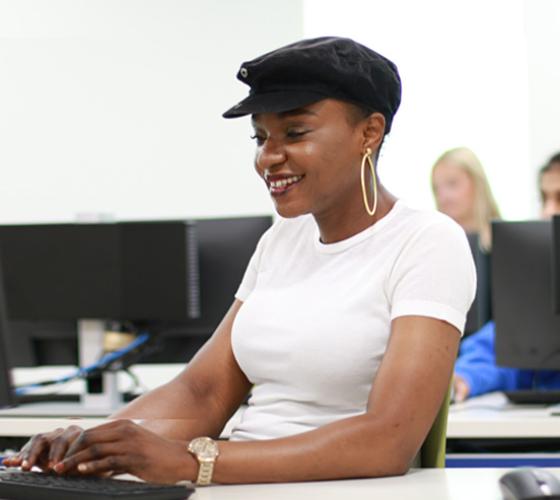 Student at computer in class smiling