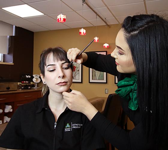 Esthetician student applying makeup to client