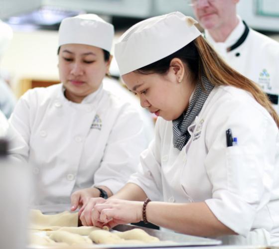 Culinary students in kitchen preparing food