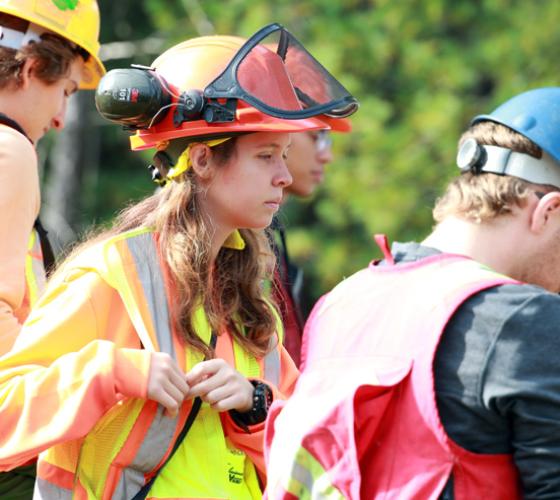 School of Natural Environment students in hard hats, vests during field camp