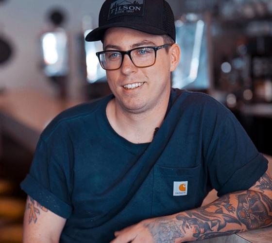 John owner and chef of Ernie's Coffee Shop smiling and talking in the restaurant