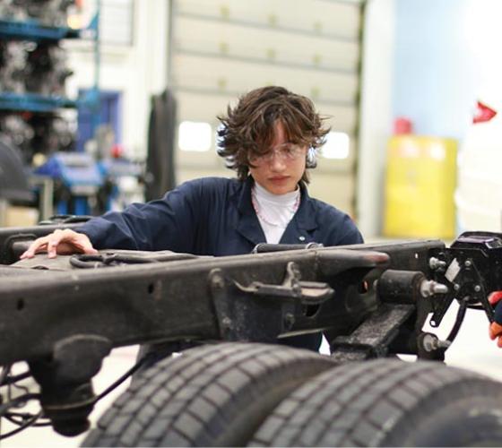 Automotive student working on heavy equipment in the lab
