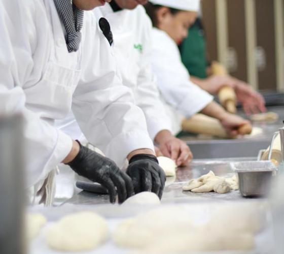 Culinary students shown prepping dough in the kitchen