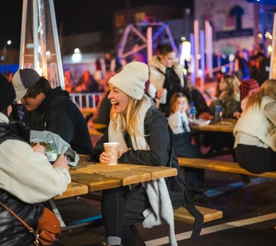 People sitting at tables outside in winter at event