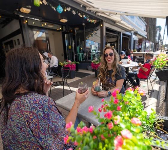 People on a downtown patio smiling and laughing on a sunny warm day