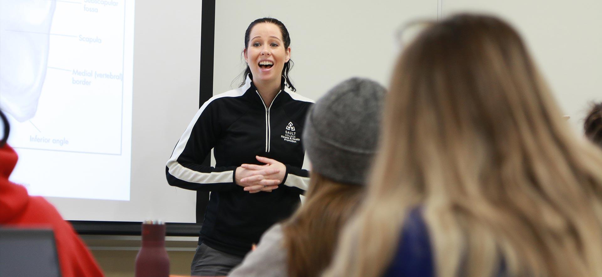 A female fitness and health instructor teaches her class.