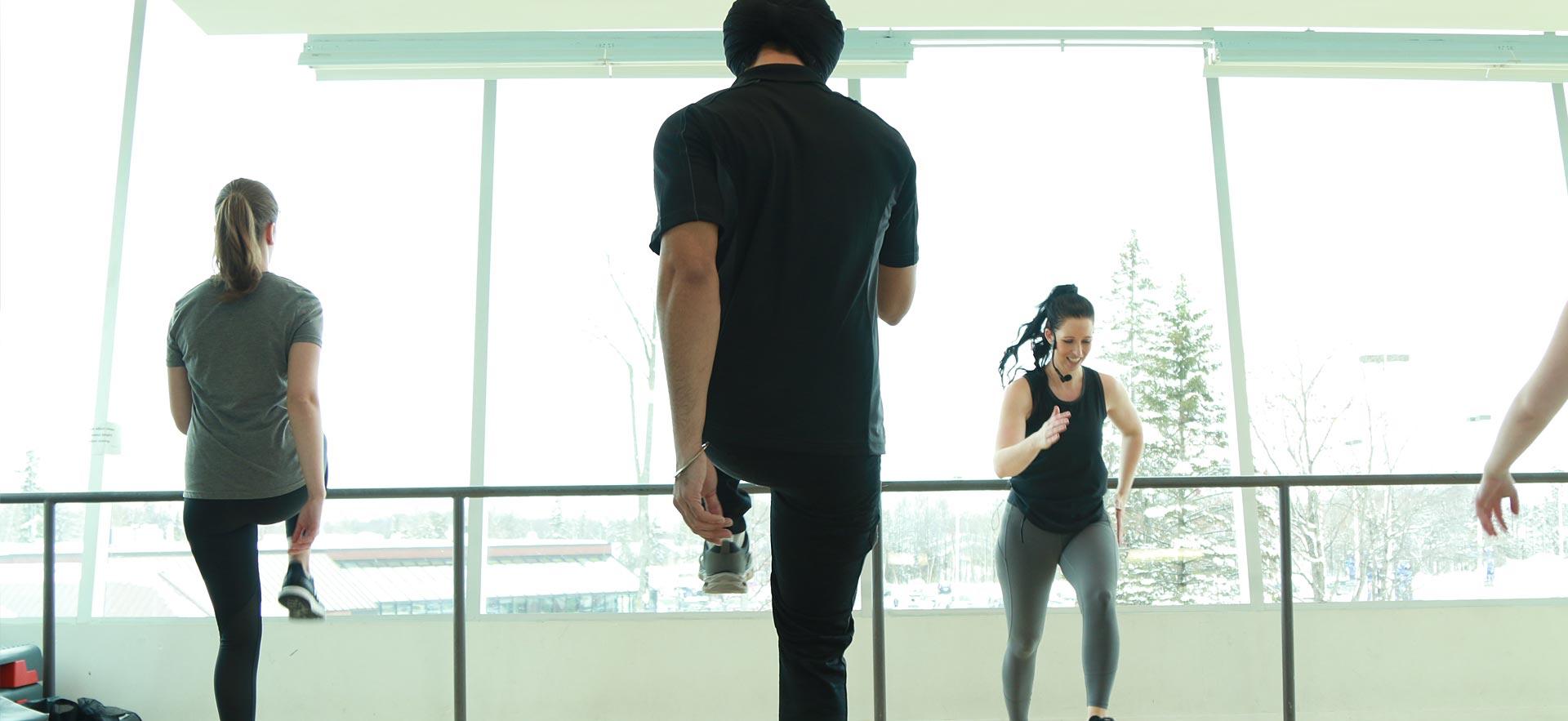 A fitness and health class participates in a group cardio/fitness class.