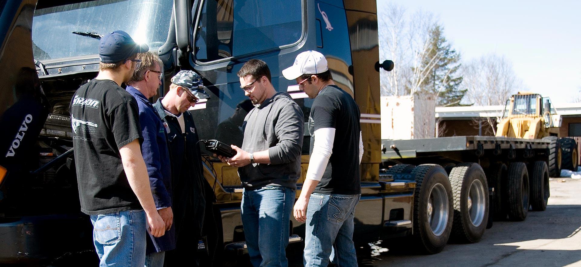 A group of male Commercial Vehicle Common Core students working on an engine. 