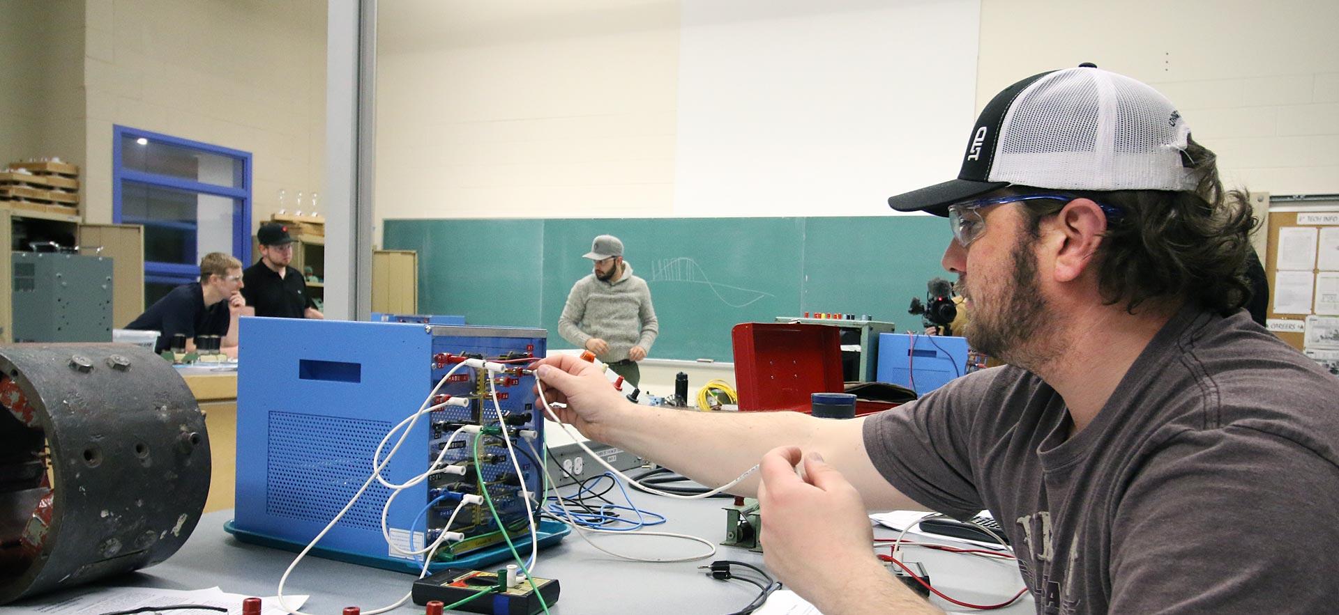 One male Construction and Maintenance Electrician student works on a class assignment. 