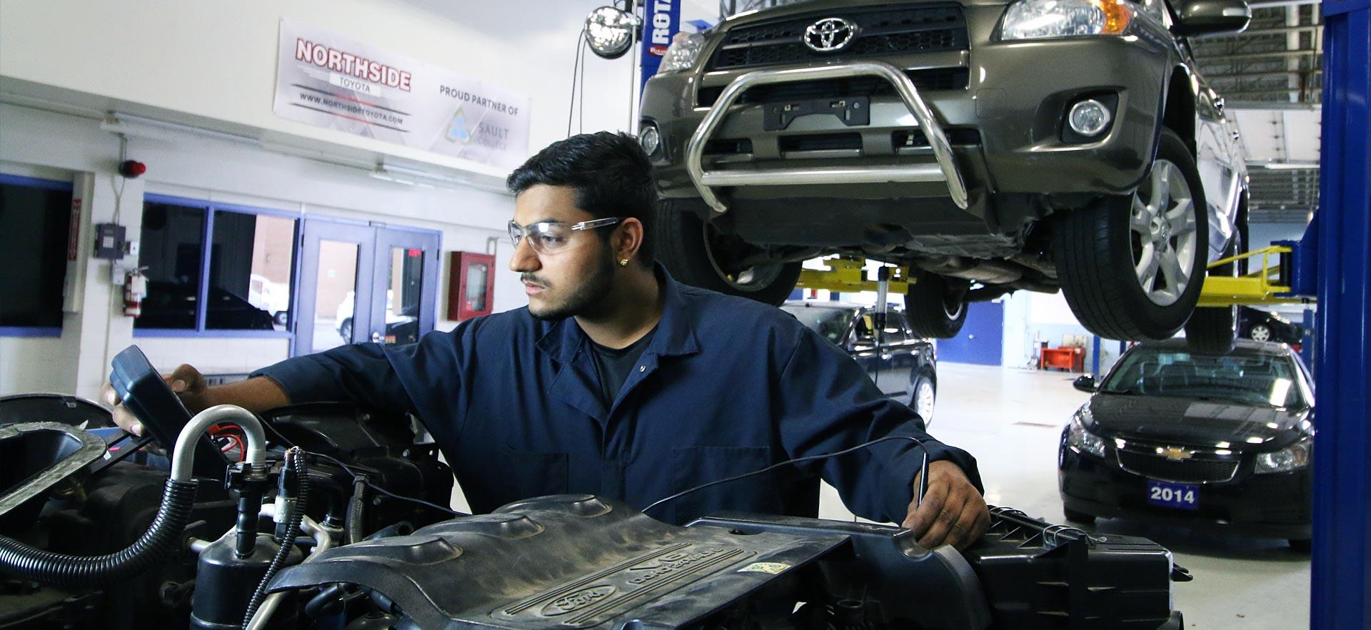 One male Automotive Service Technician student executes some diagnostic tests on an engine.                                                              