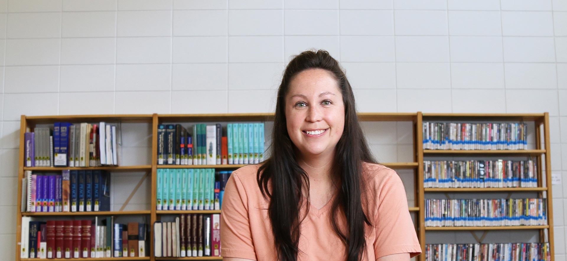 A Community Integration Through Cooperative Education student takes a break to smile in the library.  