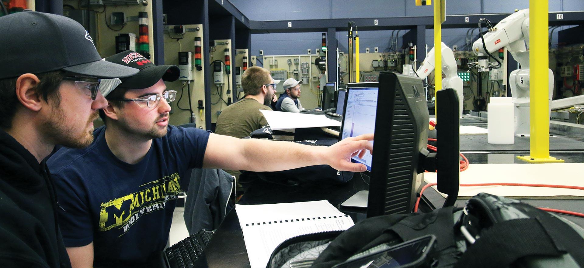 Sault College engineering students observe the technical performance of their robots in class.