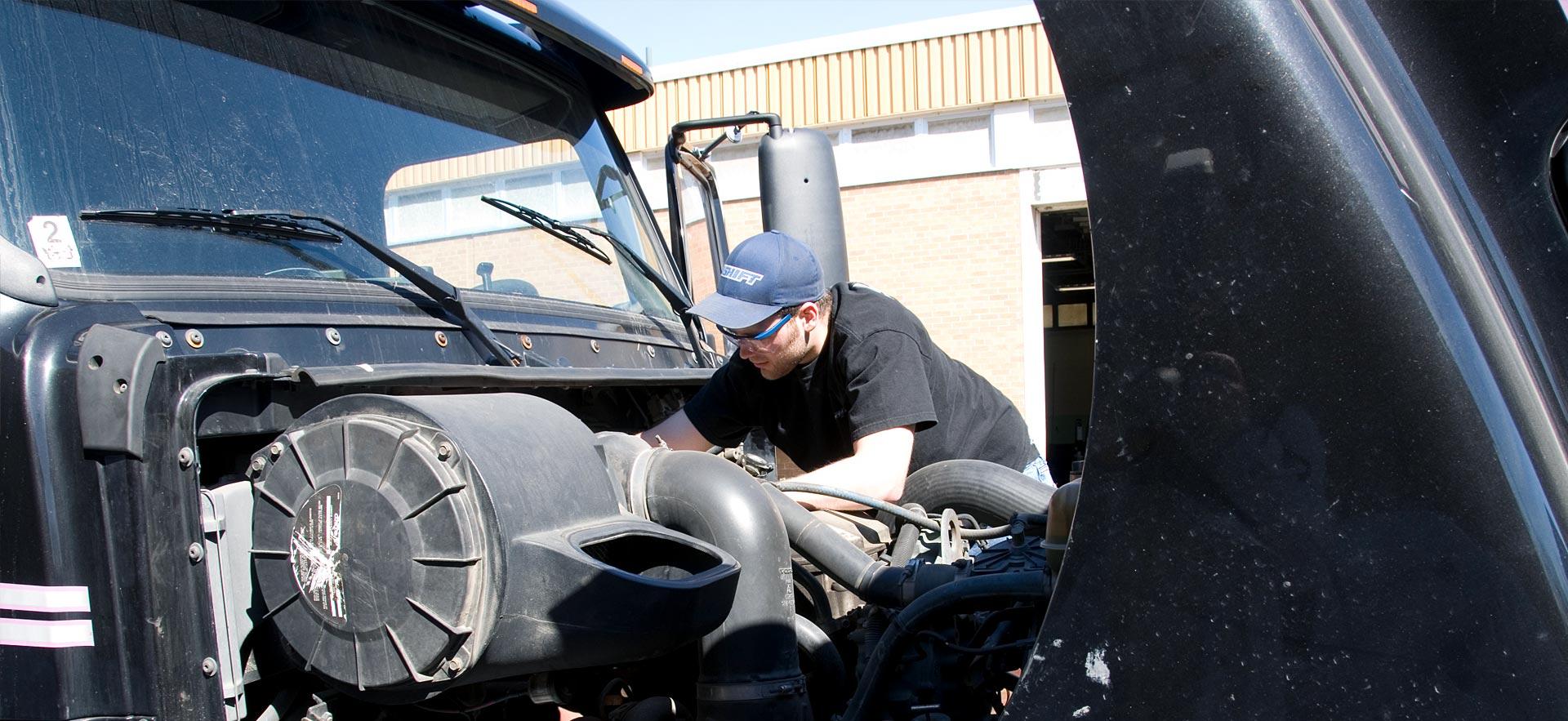 One male Motive Power Fundamentals - Heavy Equipment and Truck Repair student works on a truck engine. 