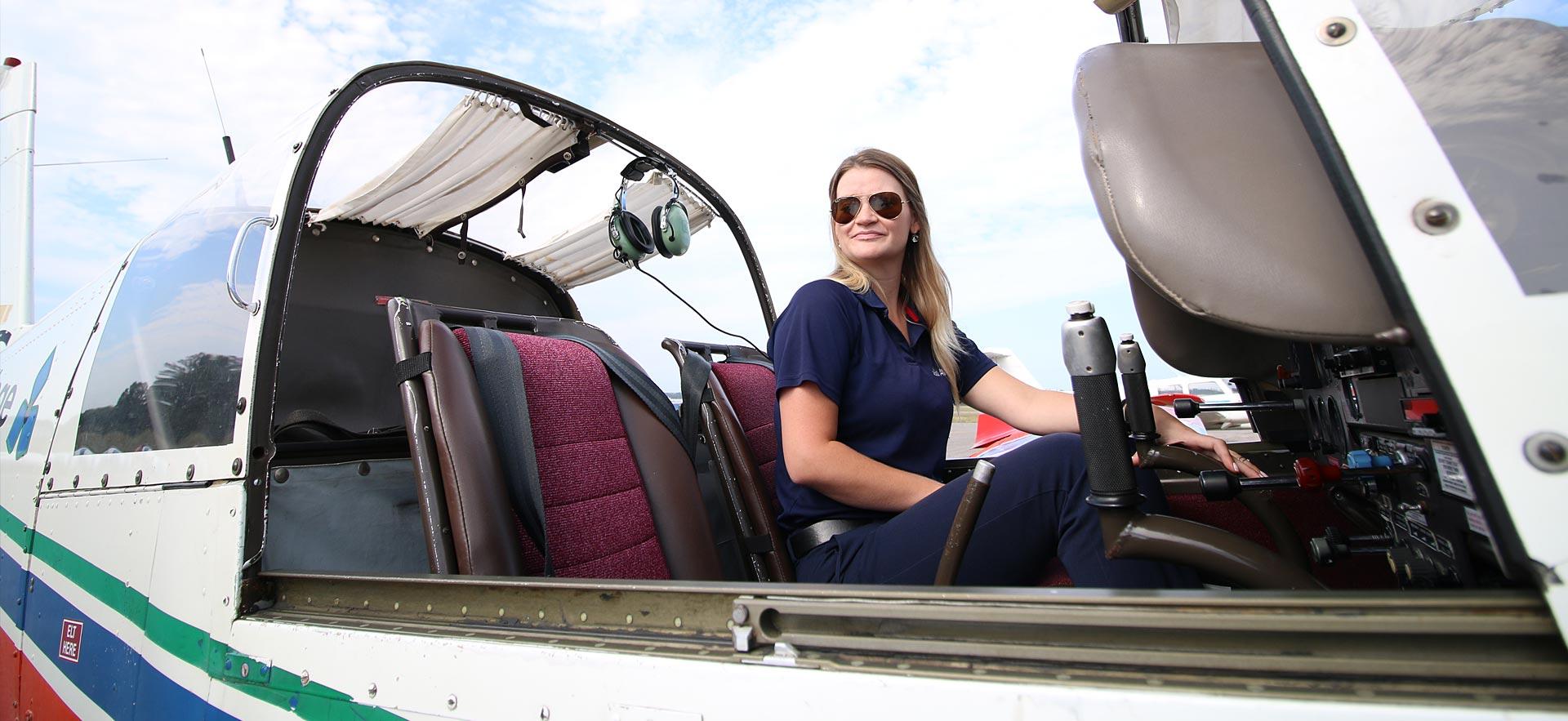 A female aviation student does a check in one of the training planes.