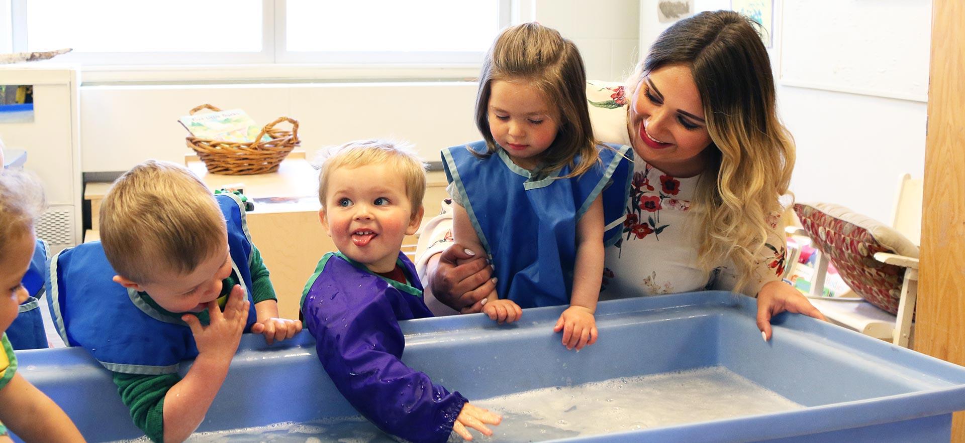 Female early childhood education student interacts with young children.