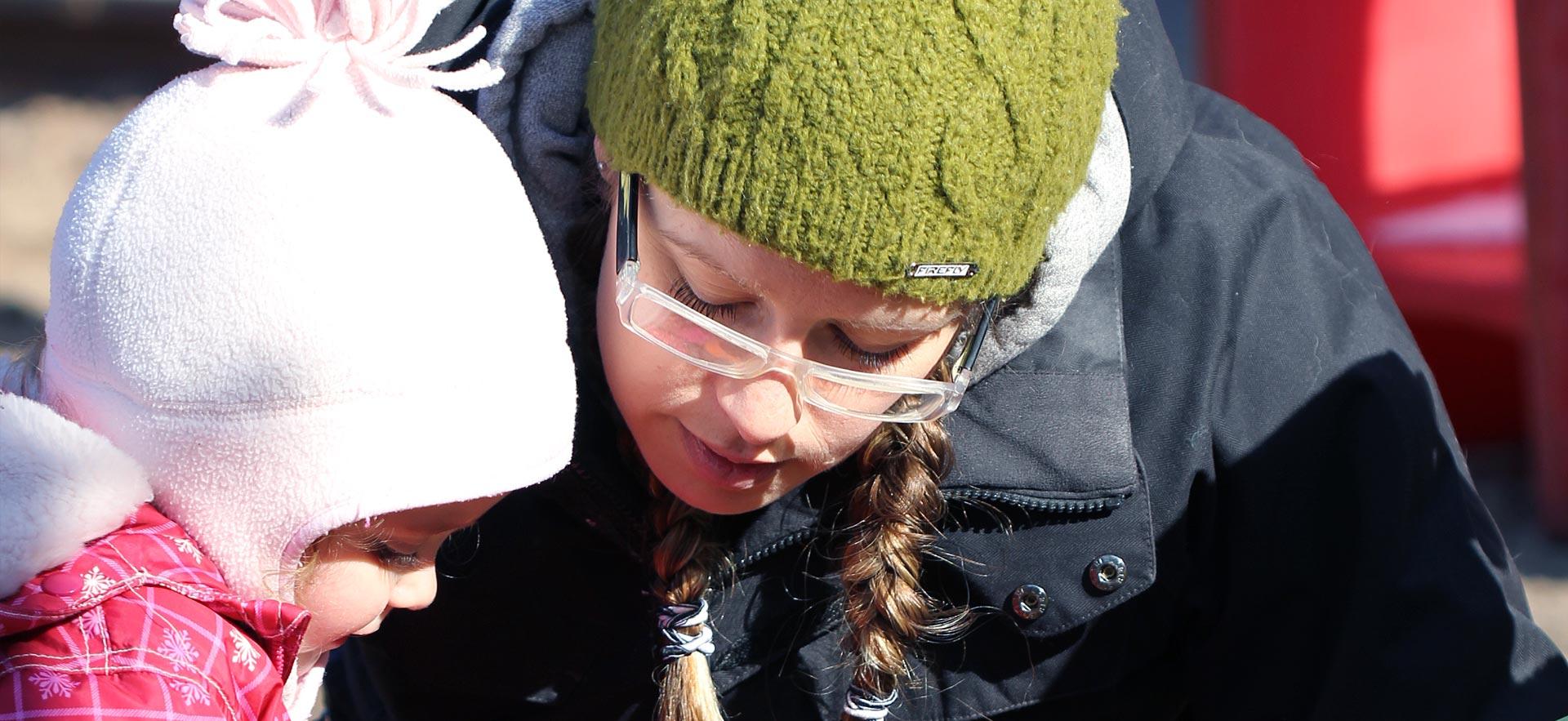 Female early childhood education student interacts with a young girl.