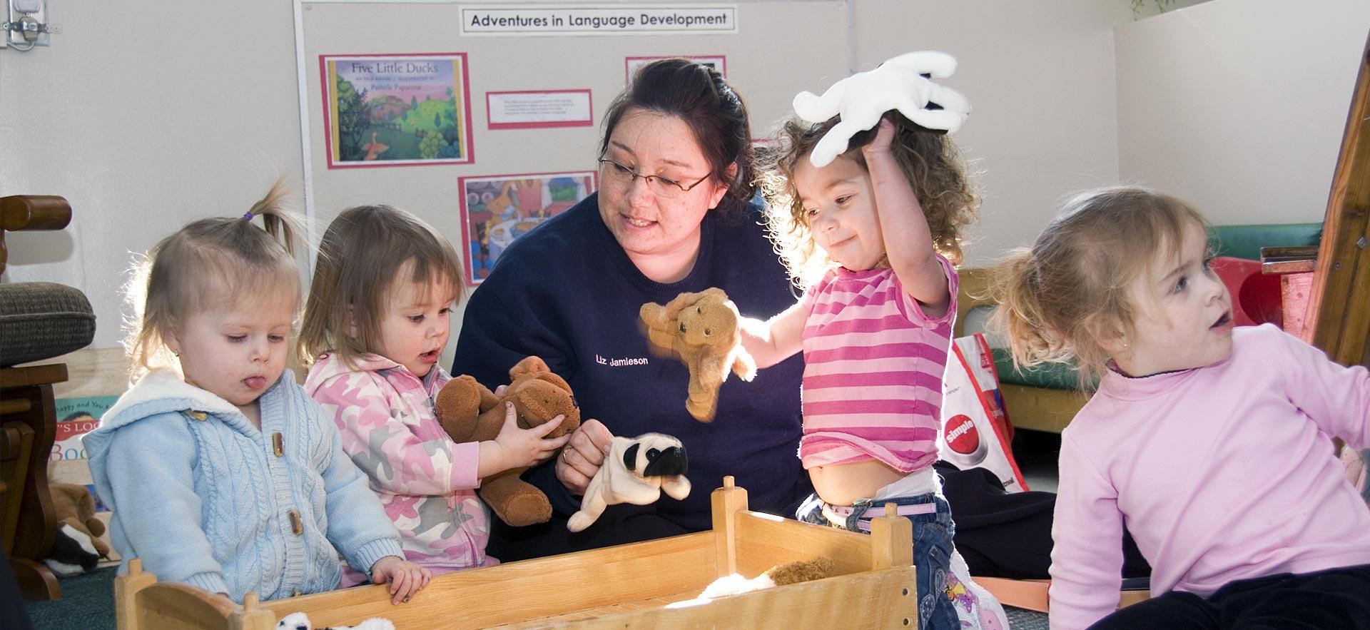 Female early childhood education student interacts with young children.