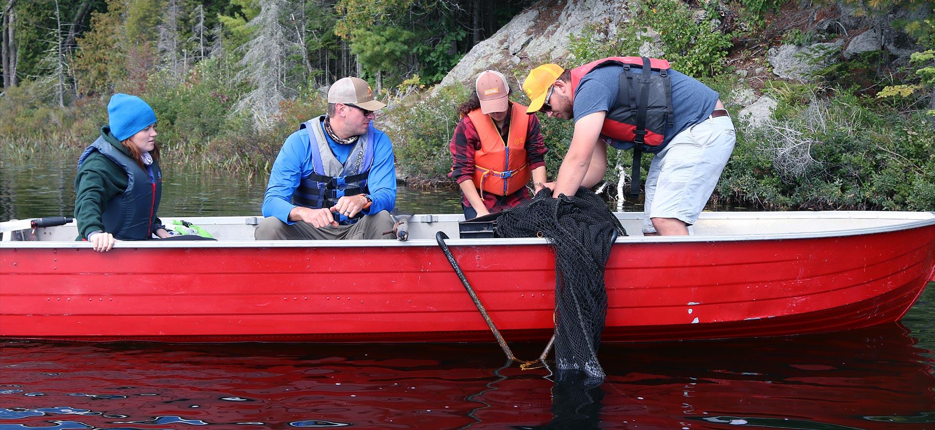 Fish and Wildlife Conservation students examine specimens on a boat