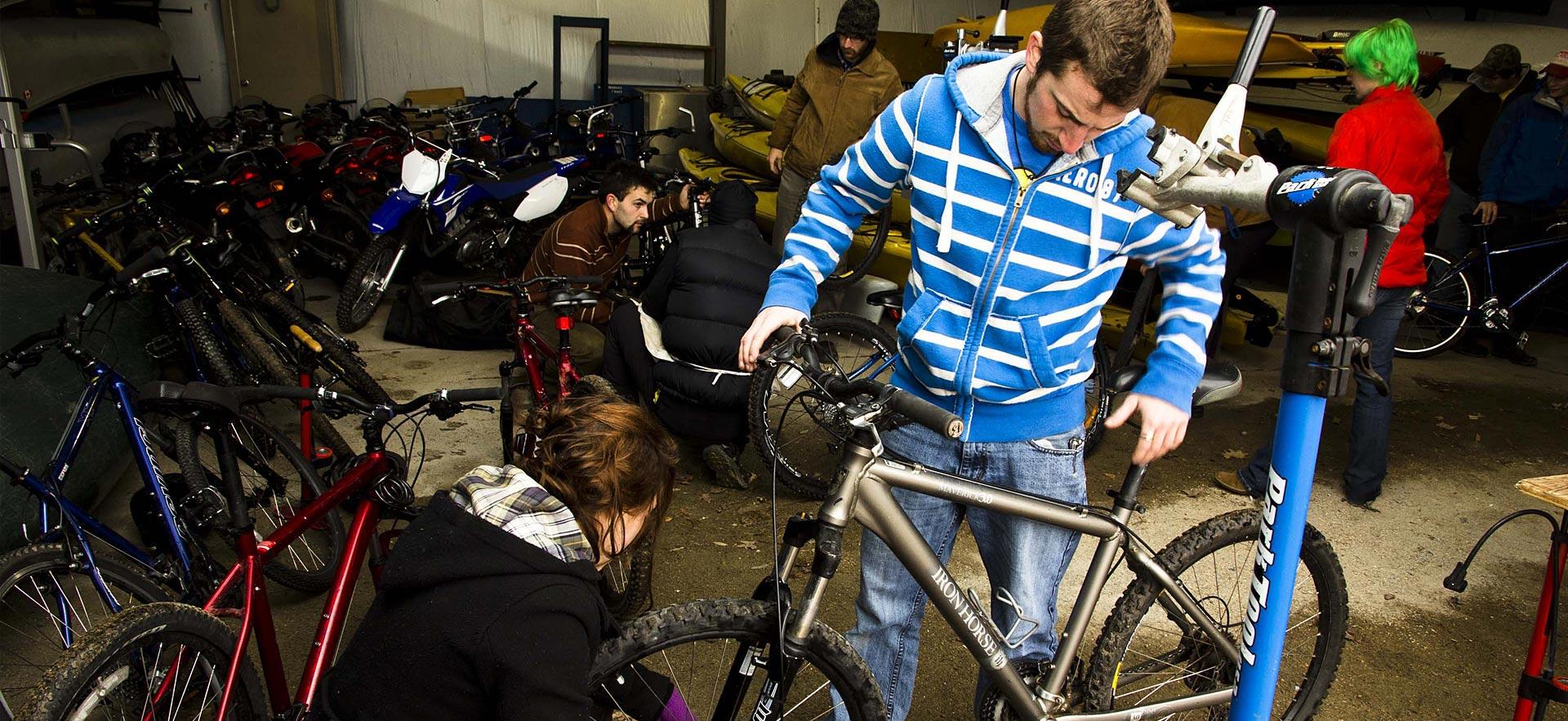 Male Adventure Recreation student examines his mountain bike