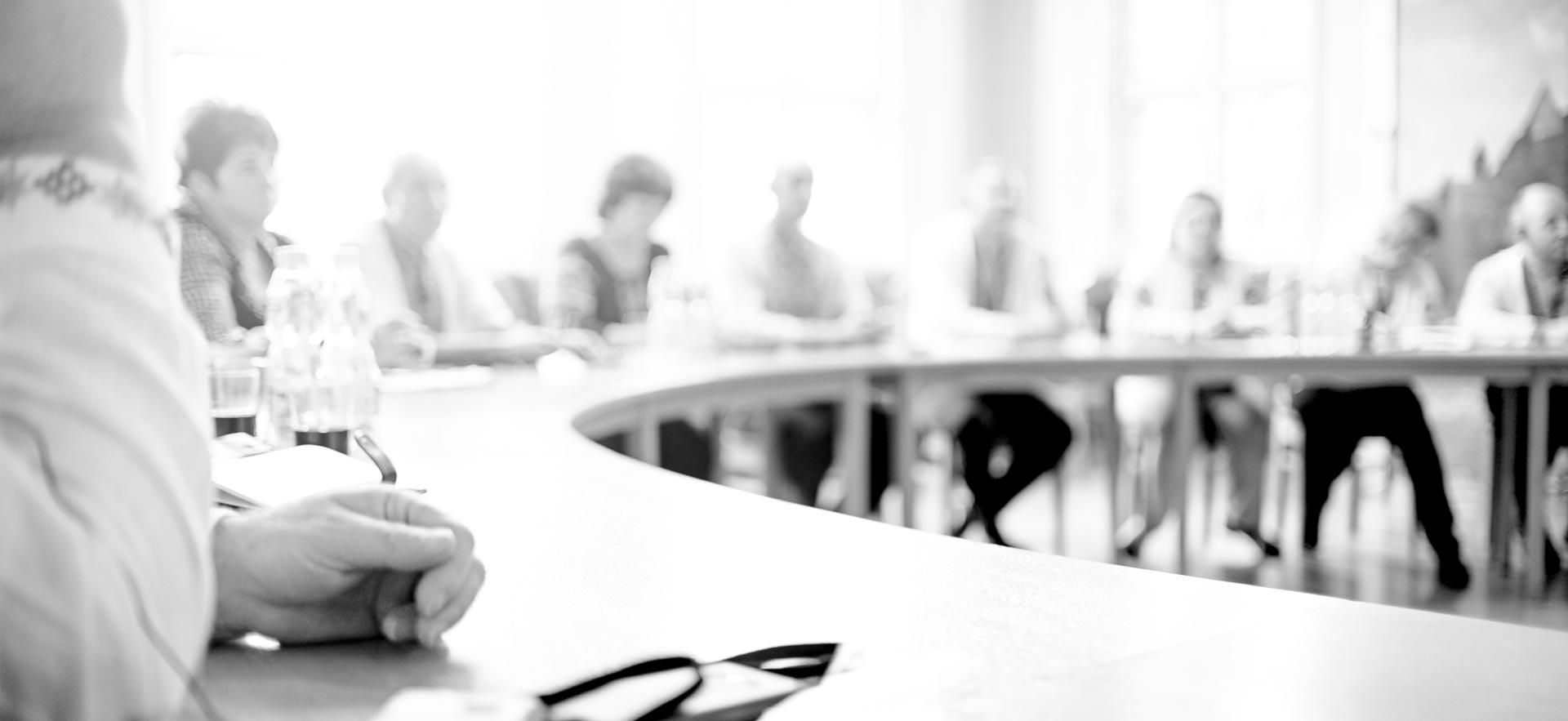 blurry black and white image of a board meeting.